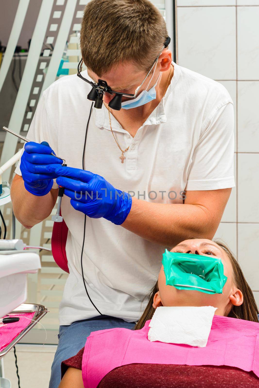 Dental restoration and polymerization of tooth composite materials, the doctor conducts sterile work on tooth restoration.2020