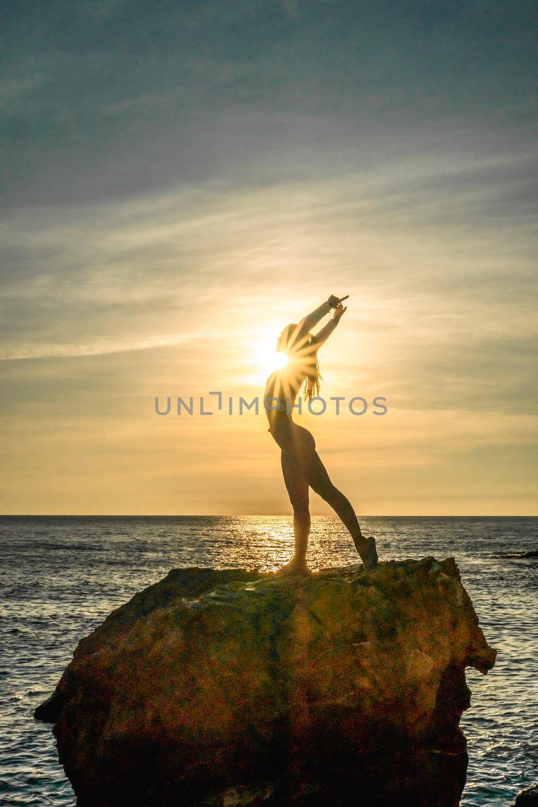 Girl gymnast is training on the beach by the sea sunset. Does twine. Photo series. by Matiunina