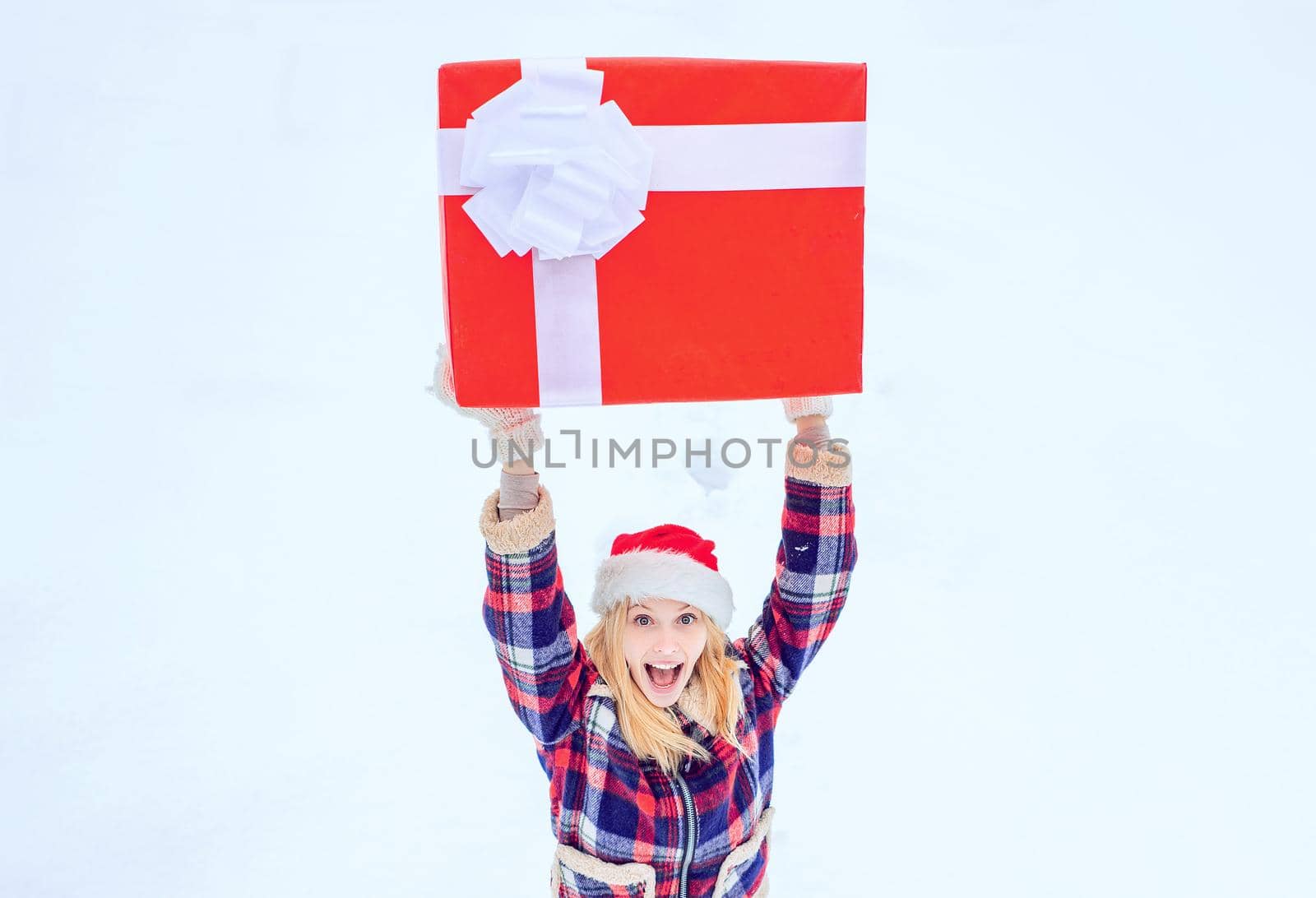 Winter woman. Hipster Girl with Christmas gift on snow Winter landscape. Winter fun activities. Winter delivery service. Packaged Christmas gift with ribbon