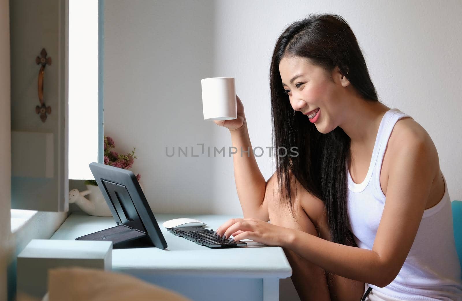 new normal, a businesswoman using tablet to work for a company Via the internet on your desk at home