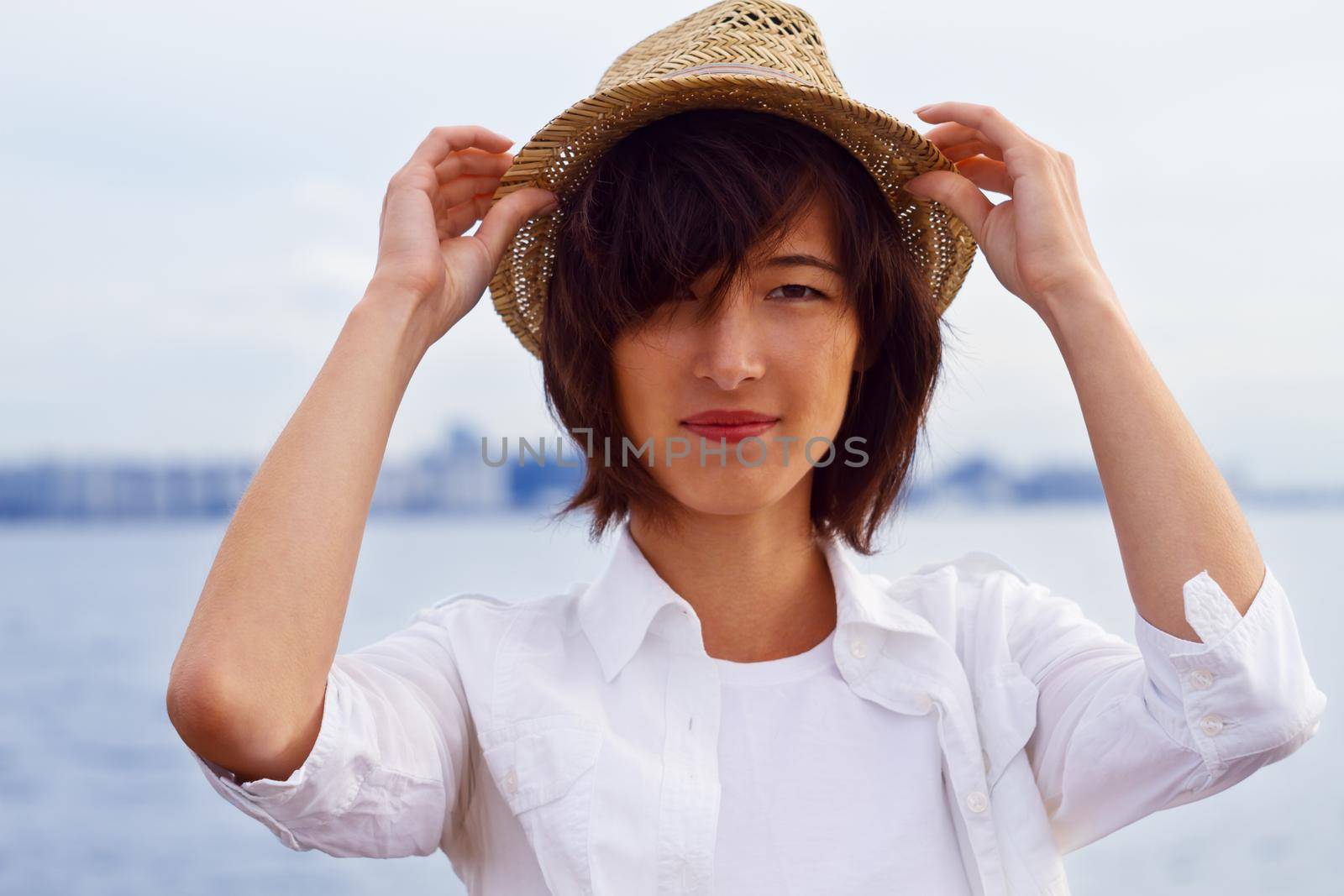 Attractive woman in a hat resting on the sea