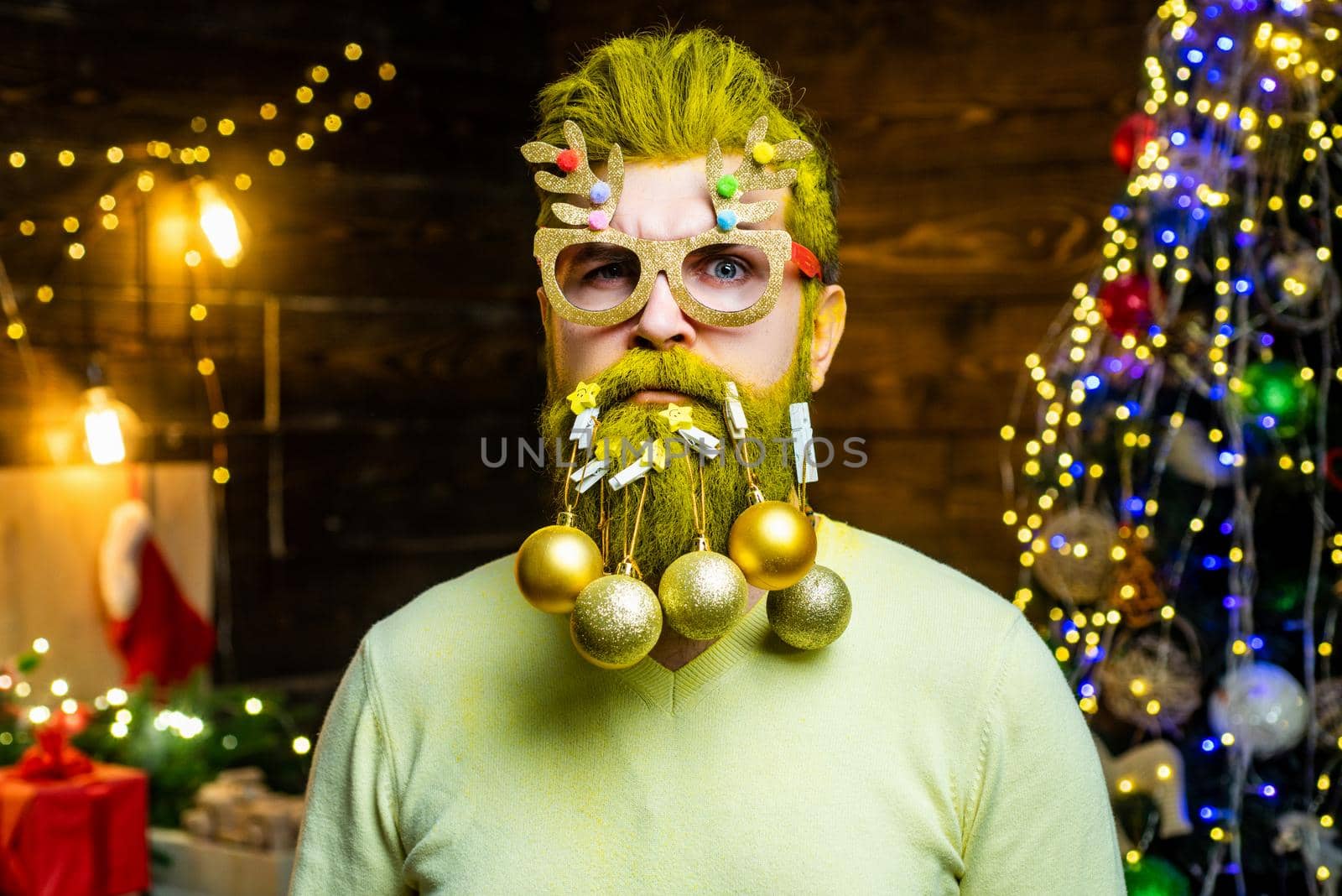 Bearded man having fun near Christmas tree indoors. by Tverdokhlib