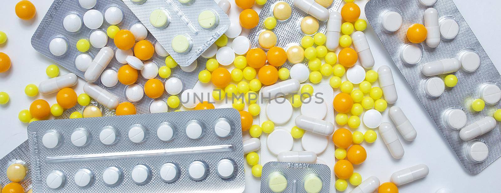 different colorful and white pills, capsules. Prevention, cure of influenza, coronavirus, covid-19. yellow, orange vitamins, tablets on white background. medical healthcare, protection concept banner