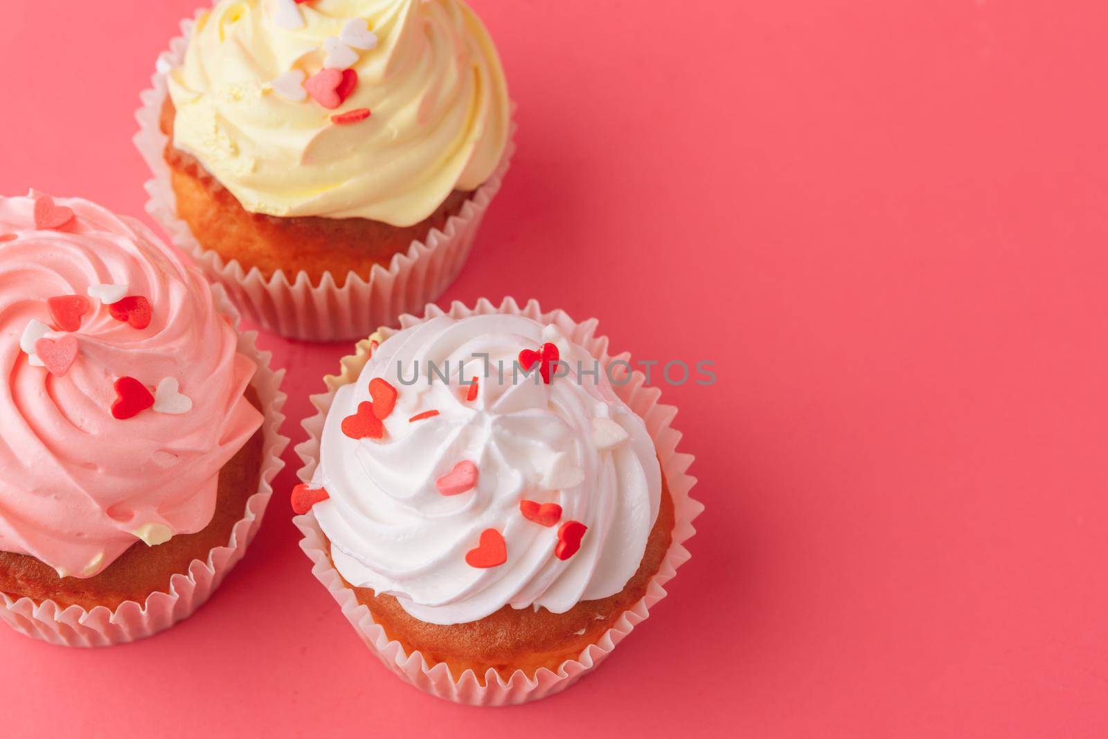 Tasty cupcakes sweets on pink background close up