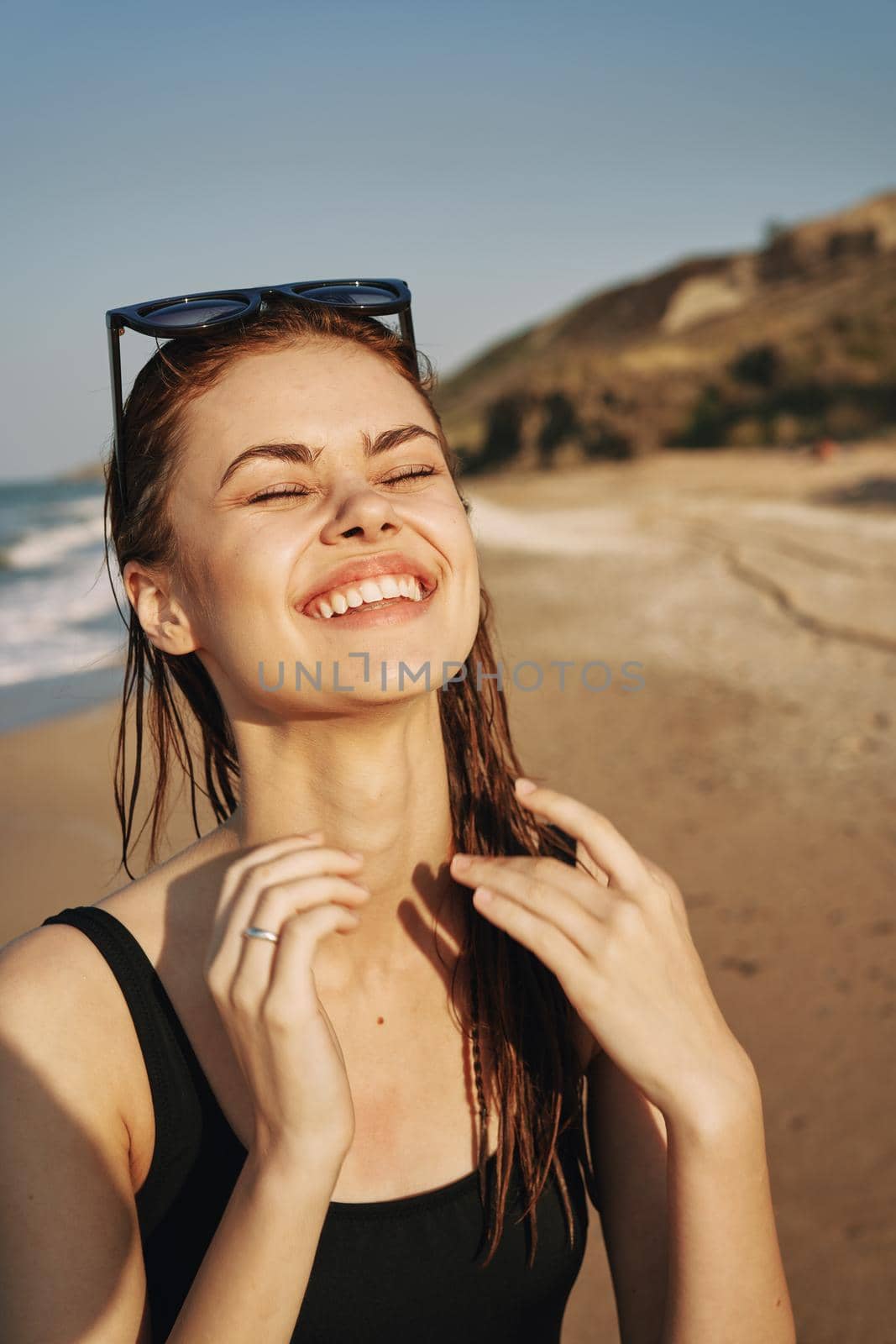cheerful woman sunglasses posing black swimsuit island. High quality photo