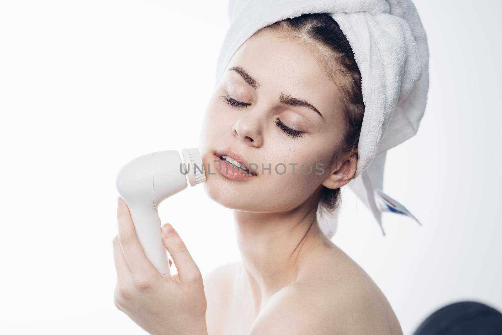 pretty woman with towel on head close-up facial massage by Vichizh