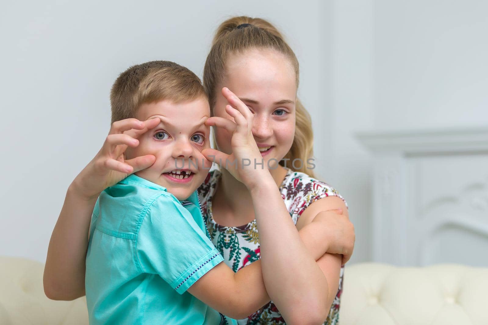 Brother and sister, boy and girl posing in the studio.