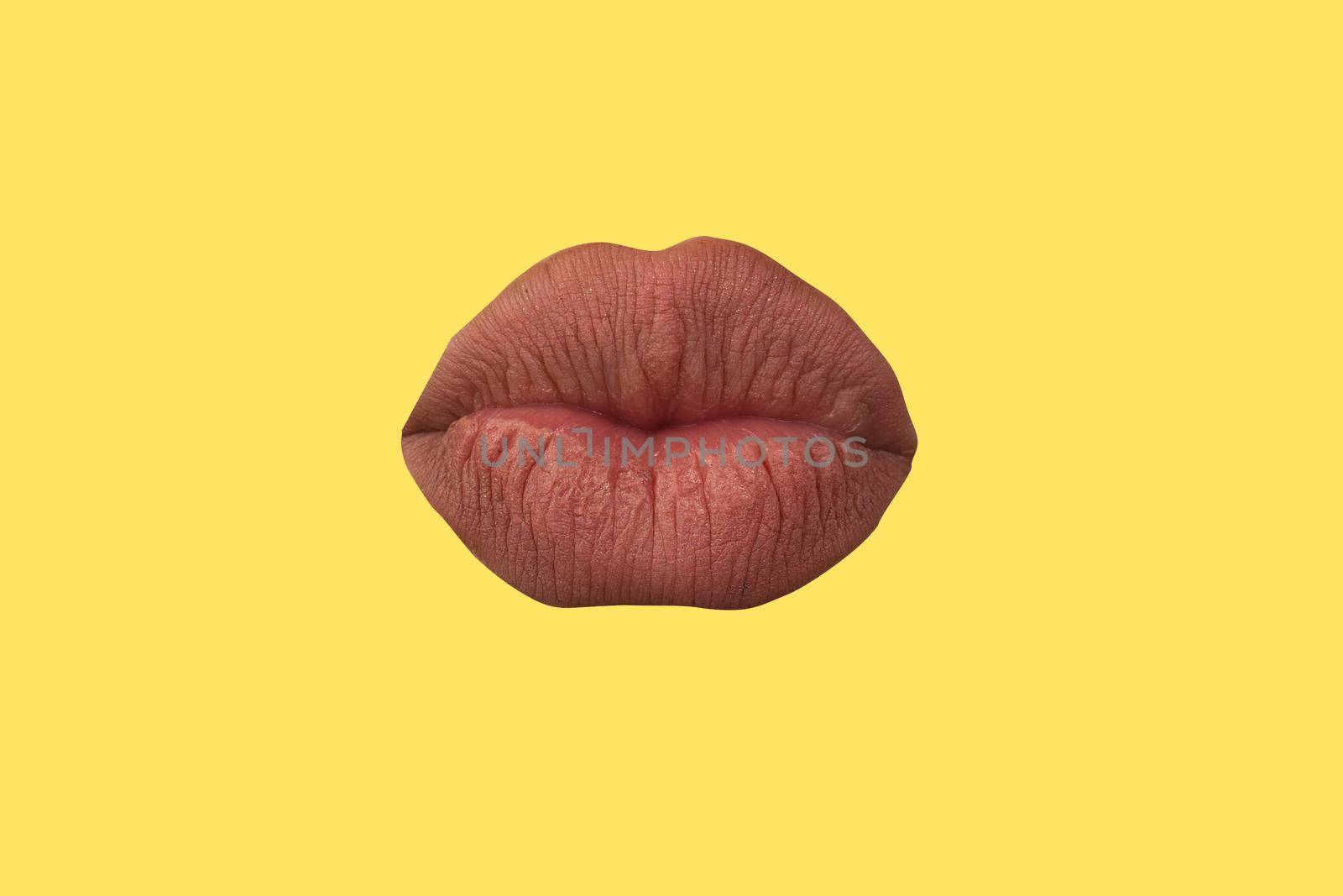Woman's lips close up isolated on yellow background.