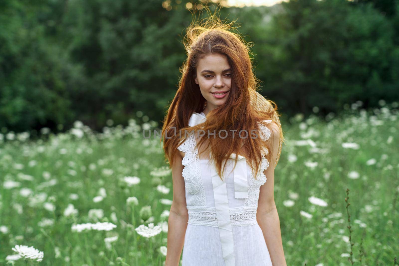 Woman in white dress in a field walk flowers vintage nature. High quality photo