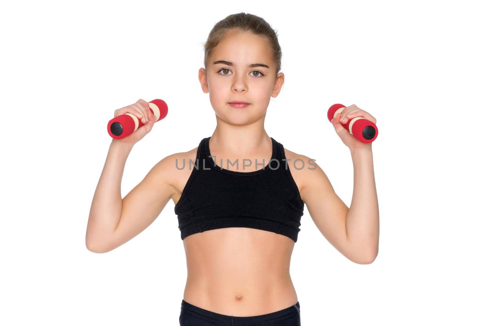 A cute little girl doing exercises with dumbbells. The concept of strength, health and sport. Isolated on white background.