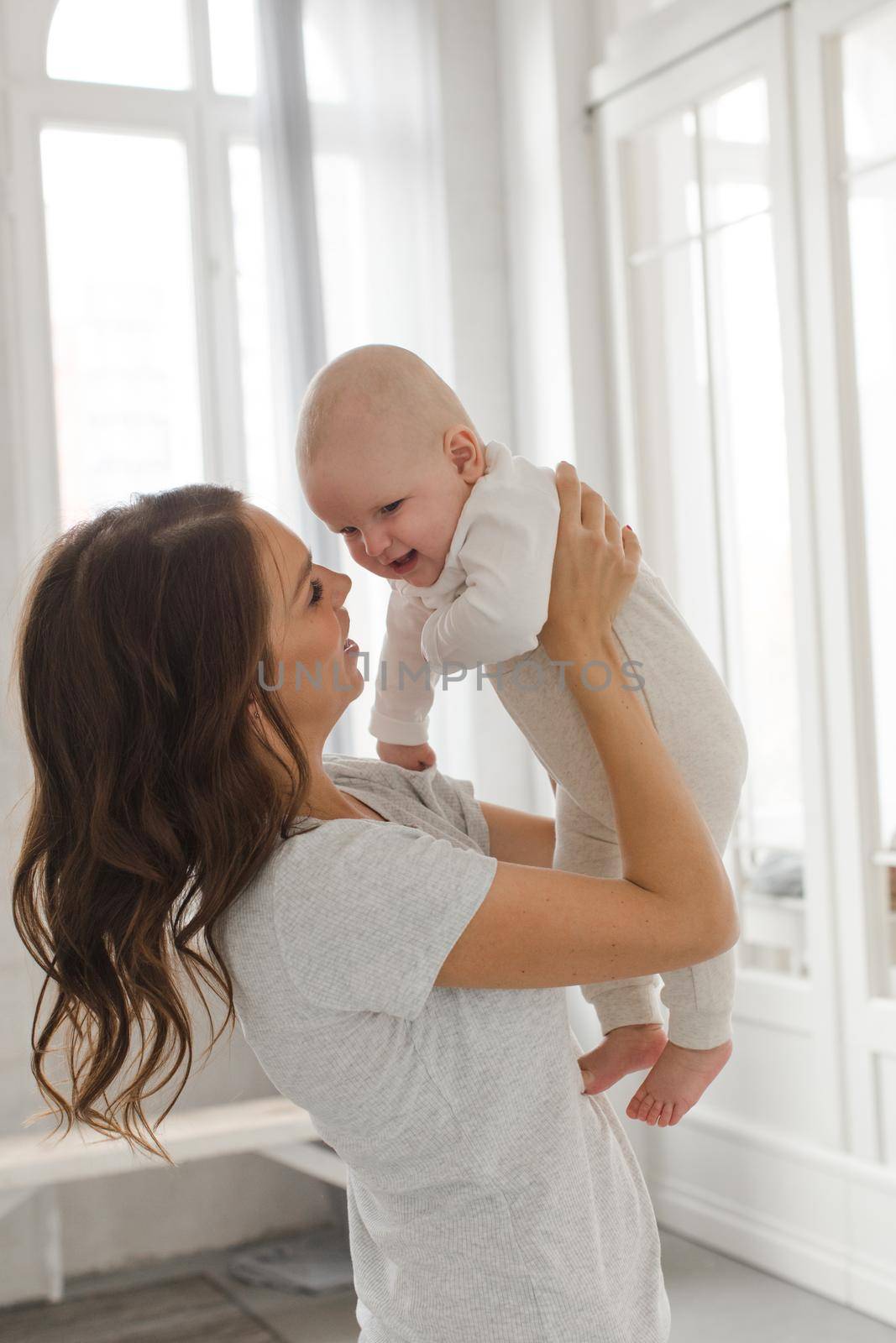 Cheerful woman playing with adorable infant child.