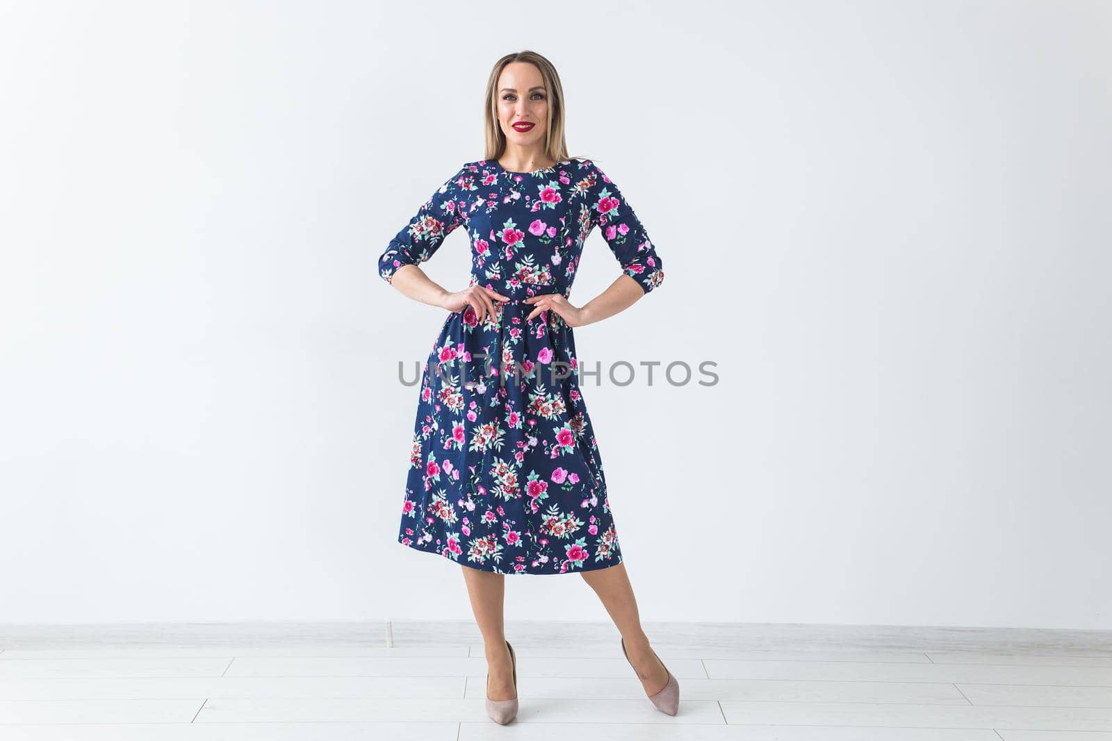 Fashionable young woman in beautiful dress posing at studio. Isolated over white.