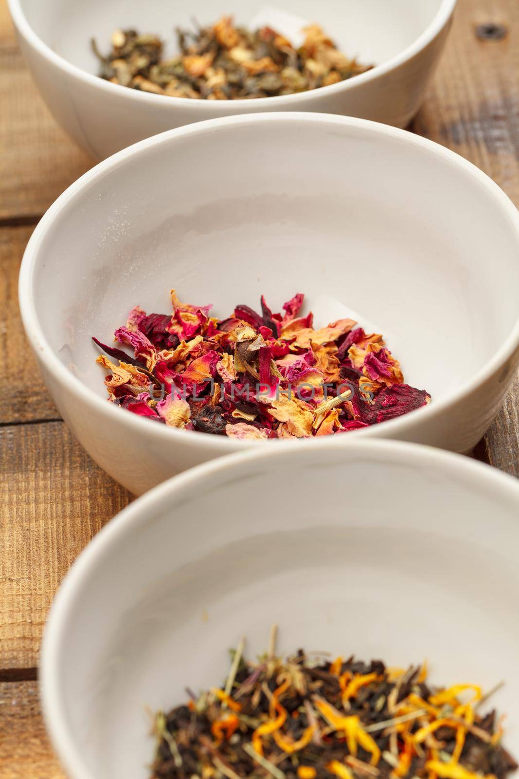 Aromatic dry tea in bowls on wooden background