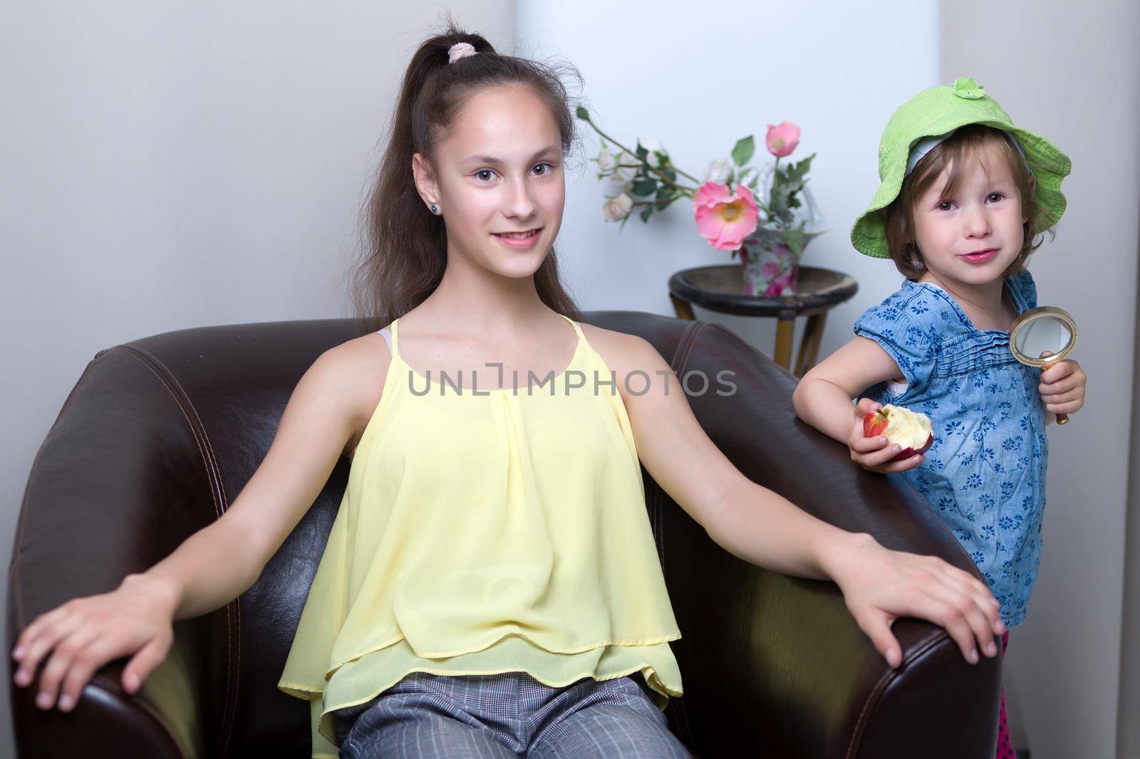 Two older and younger girls, two sisters fun posing in the studio. The concept of family, friendship.