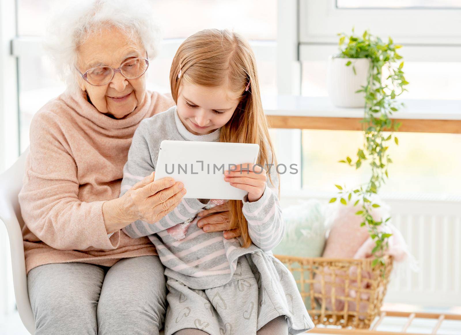 Granddaughter with granny using tablet at home