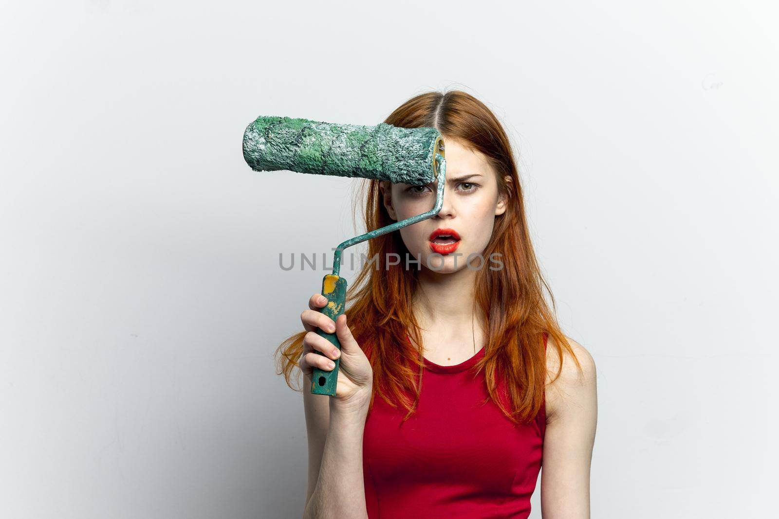 pretty woman in red t shirt paint roller housework. High quality photo