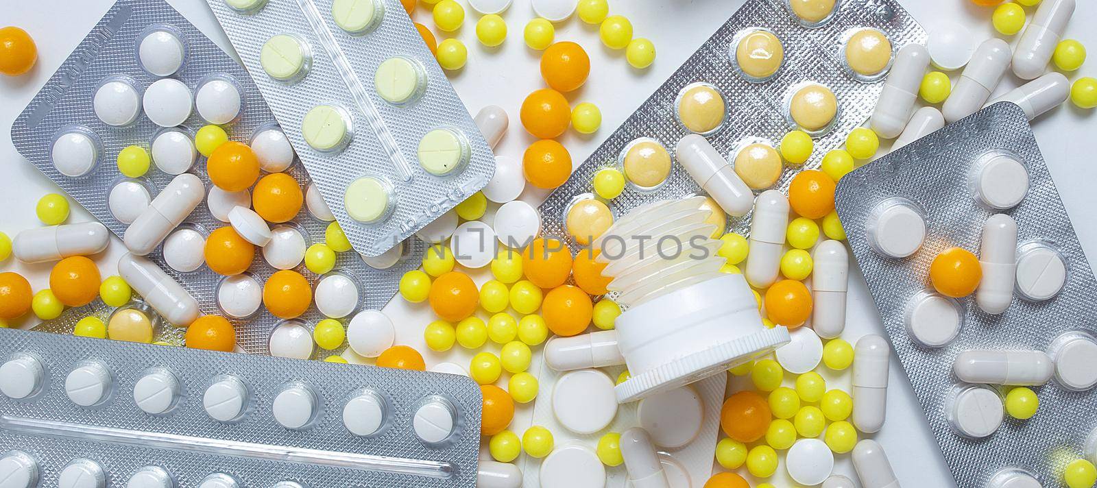 different colorful and white pills, capsules. Prevention, cure of influenza, coronavirus, covid-19. yellow, orange vitamins, tablets on white background. medical healthcare, protection concept banner