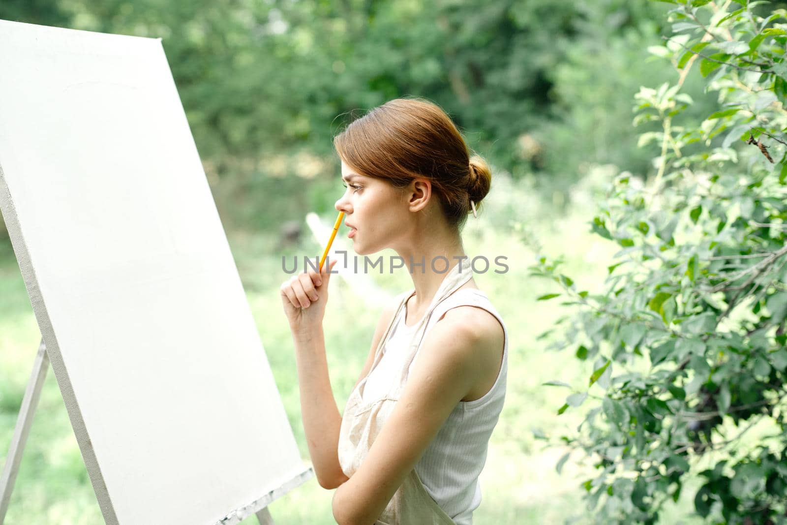 Cheerful woman artist nature easel creative art. High quality photo