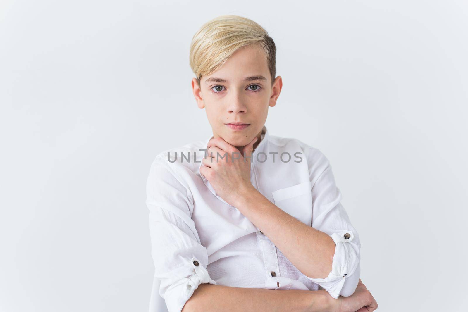 Solitude, loneliness and boredom concept - Bored teen student sitting in a school chair isolated on white