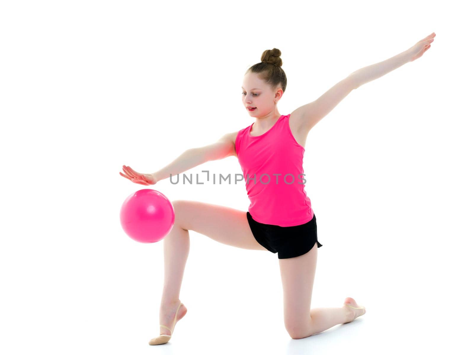 A charming little girl is engaged in fitness with a ball. The concept of gymnastics, health and sports. Isolated on white background.