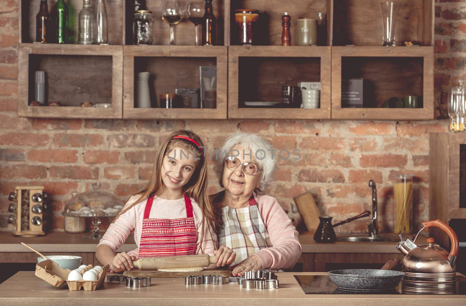 Granny with granddaughter roll out the dough by tan4ikk1