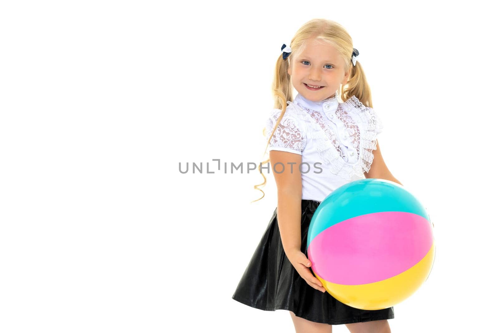 A good girl is playing with a big inflatable ball. The concept of a happy childhood, recreation in nature, exercise. Isolated on white background.