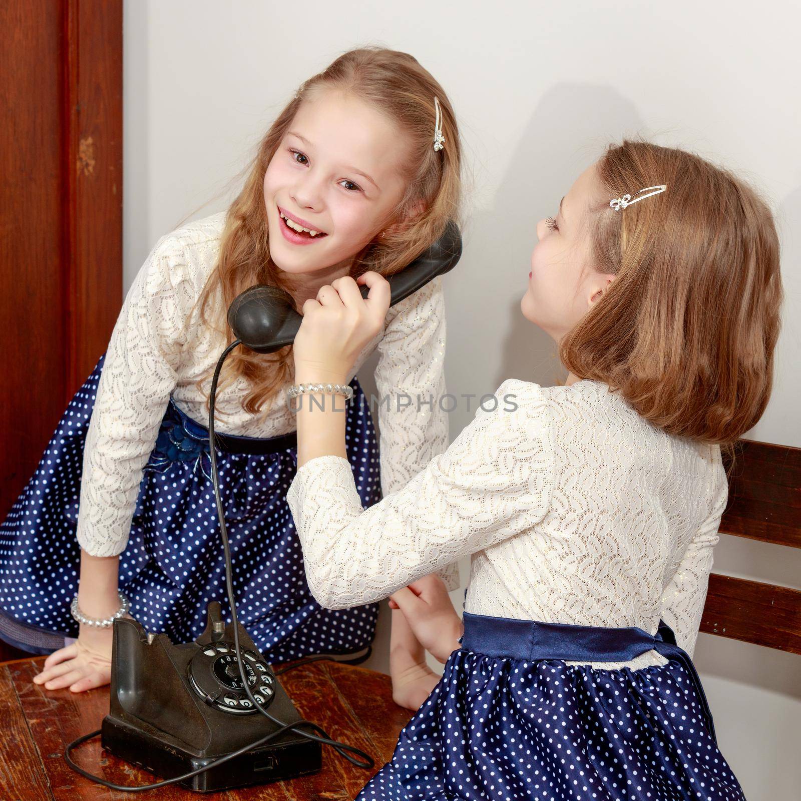 Two sisters talking on old phone by kolesnikov_studio