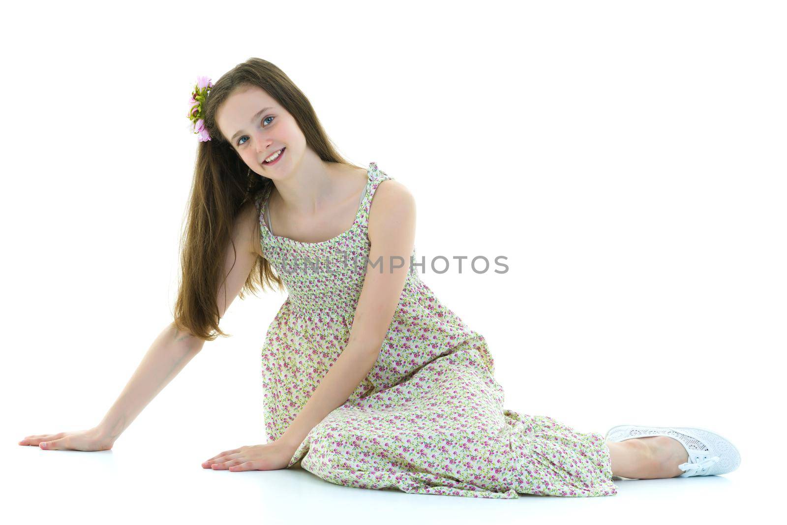 Teen girl teenager sitting on the floor in the studio. The concept of style and fashion. Isolated on white background.