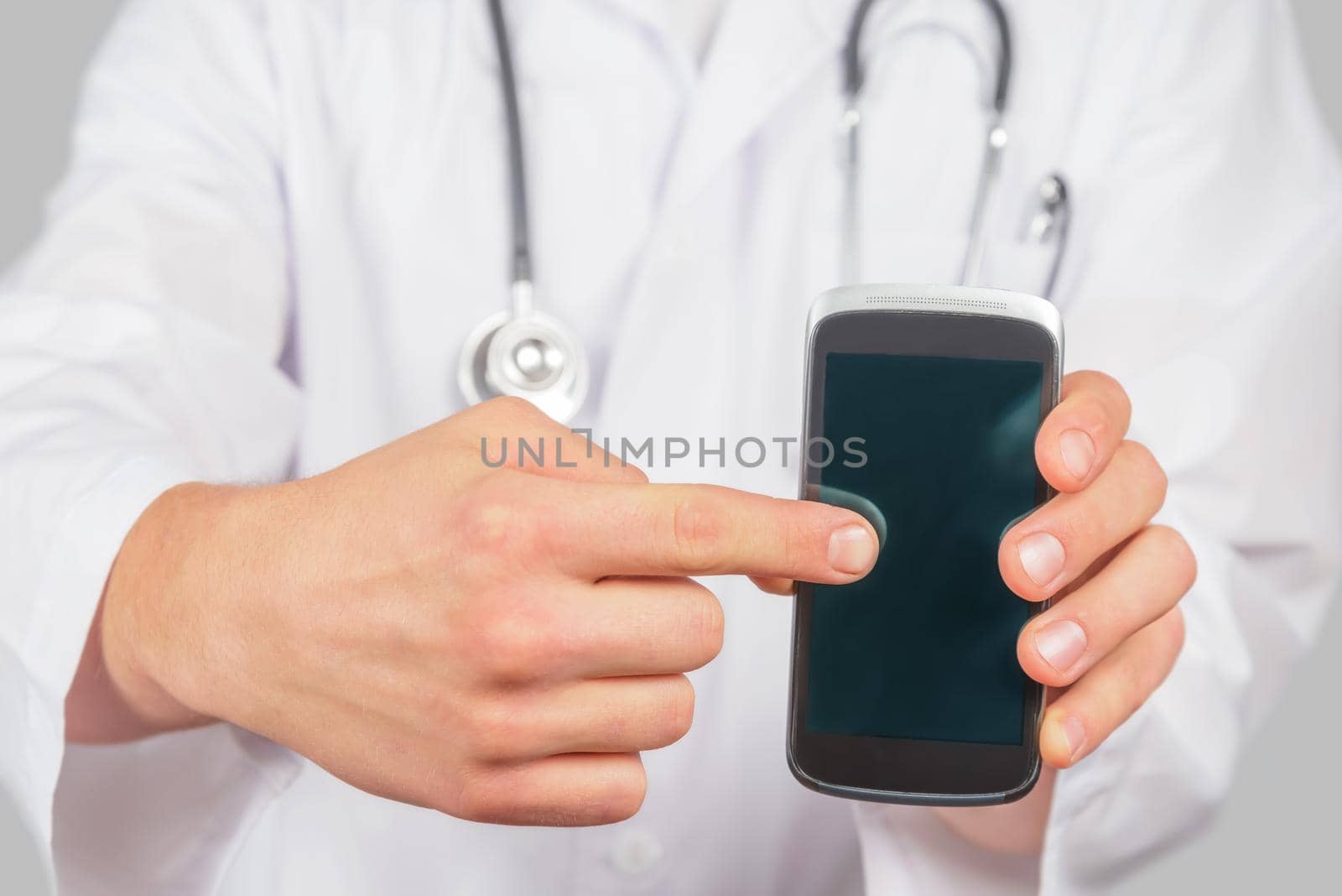 Doctor is pointing on mobile phone, copyspace by alexAleksei