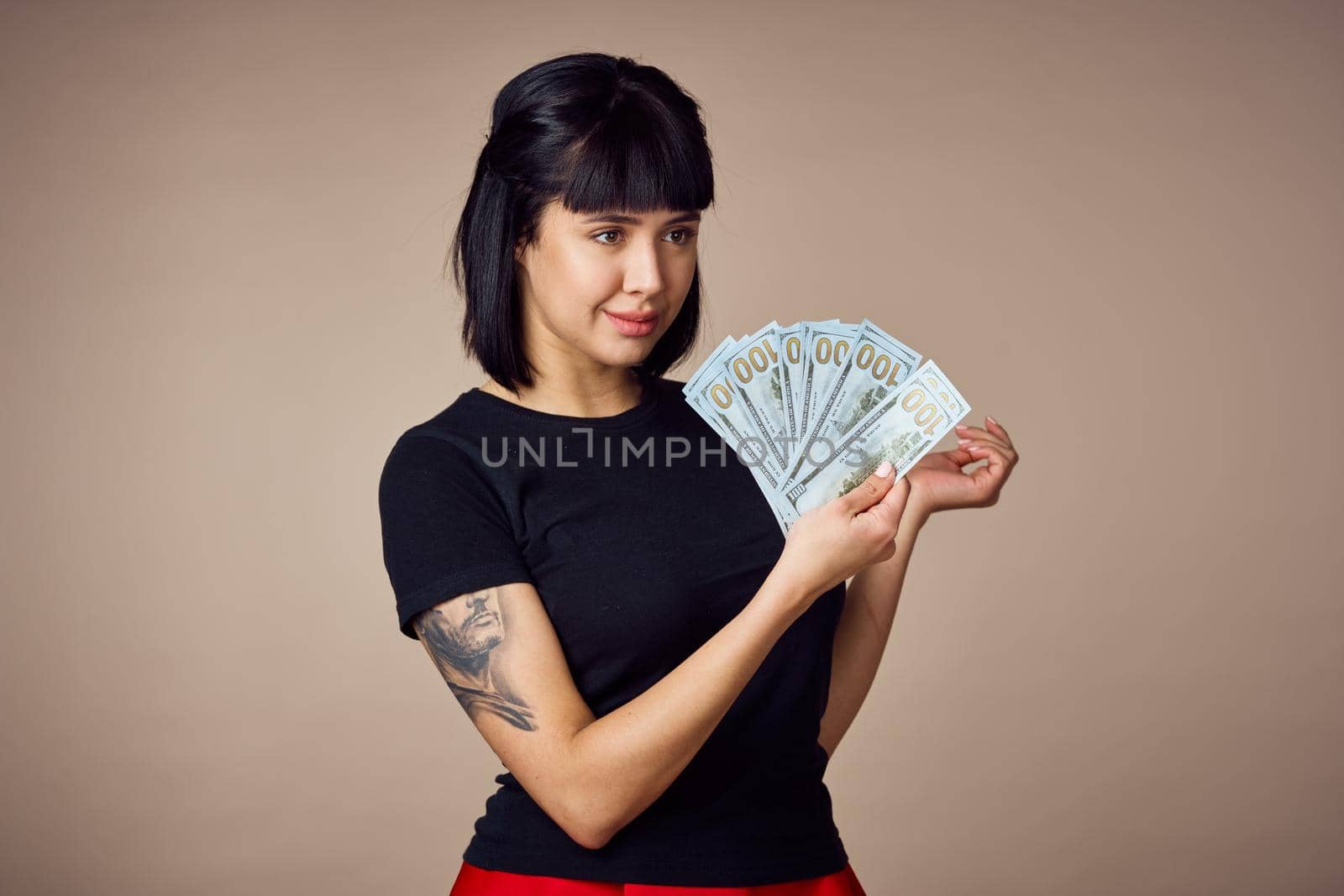 woman in a black t-shirt a wad of money dollars payment beige background. High quality photo