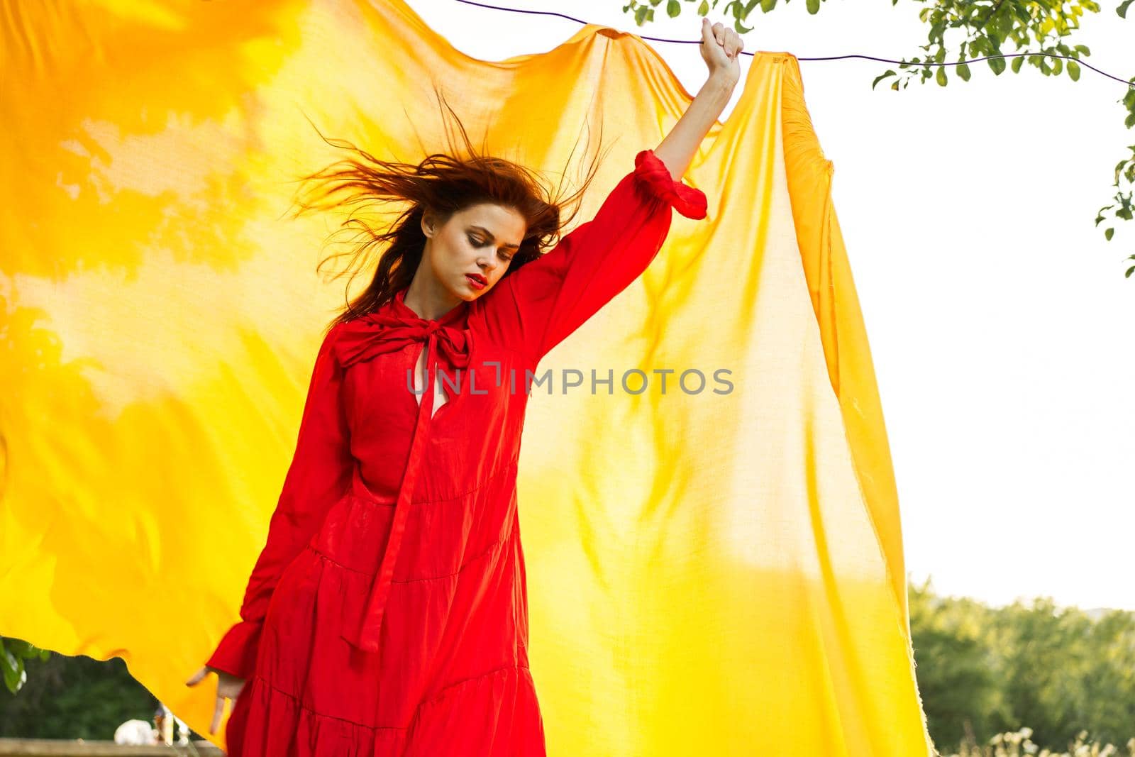 attractive woman in red dress posing yellow background nature. High quality photo