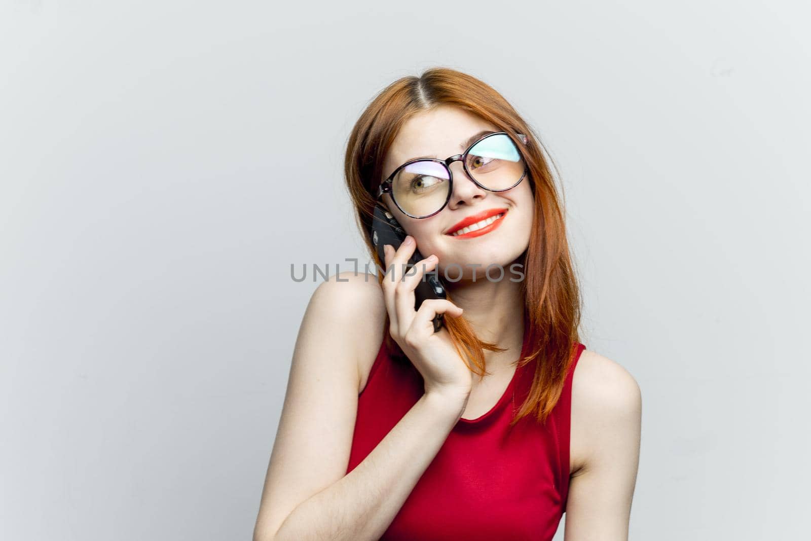emotional red-haired woman with a phone in her hands communicating gadget. High quality photo