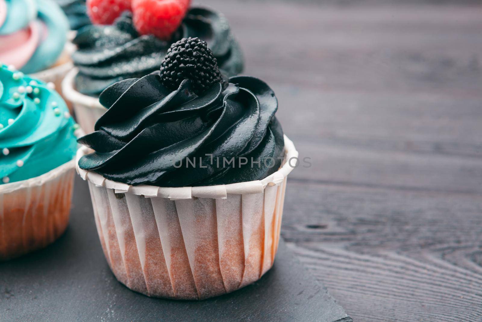 Set of different delicious cupcakes on dark