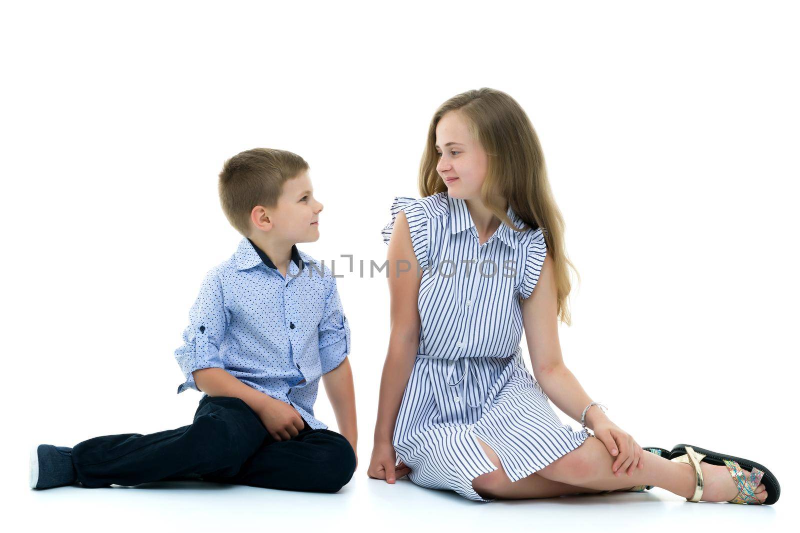 Boy and girl, brother and sister posing in the studio. Concept of family values, friendship, game. Isolated on white background