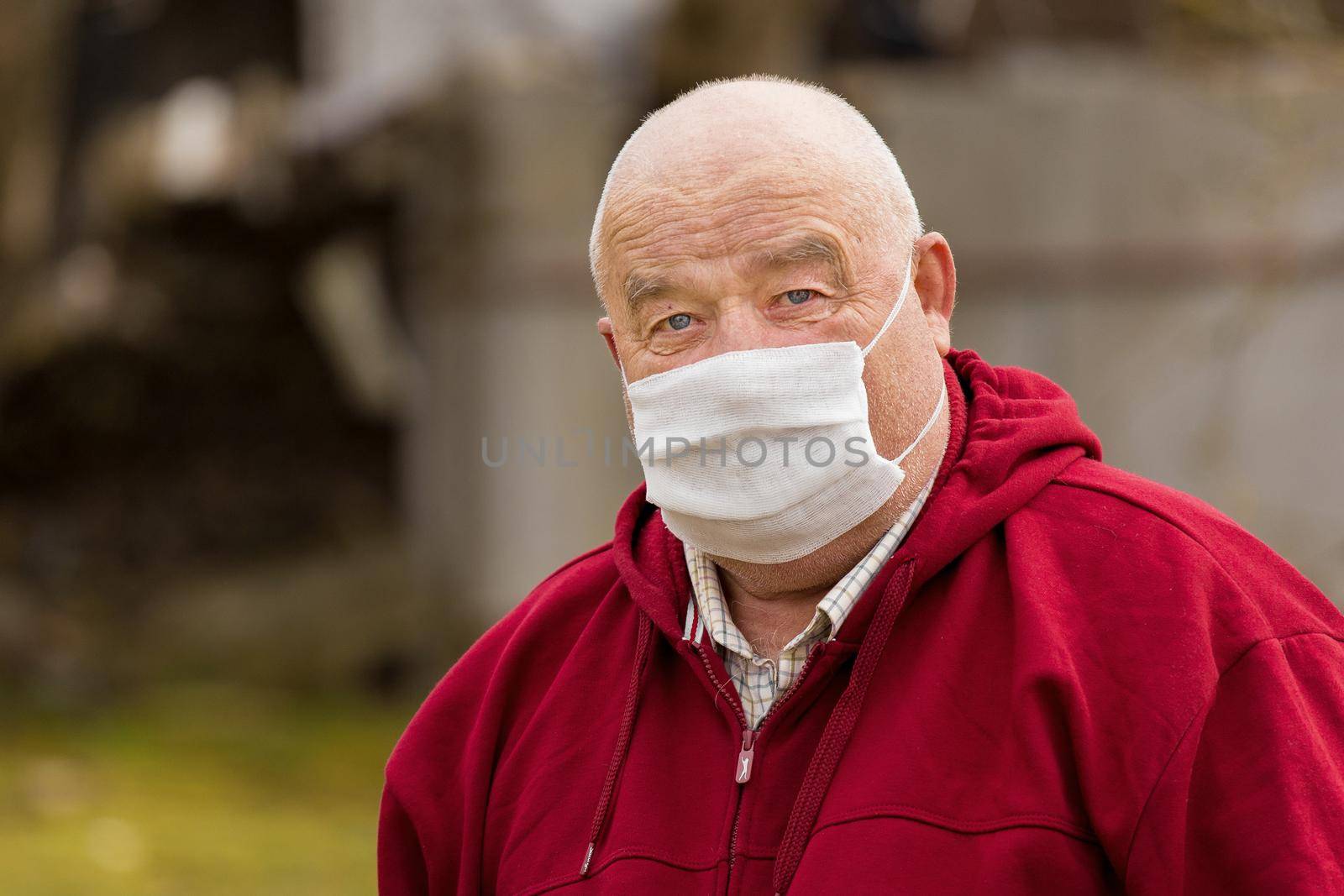 Portrait of an elderly European man with a short haircut in a protective safe medical mask, close-up.