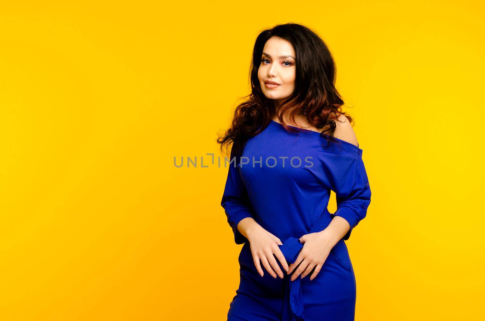 beautiful adult woman in a suit on a yellow background.