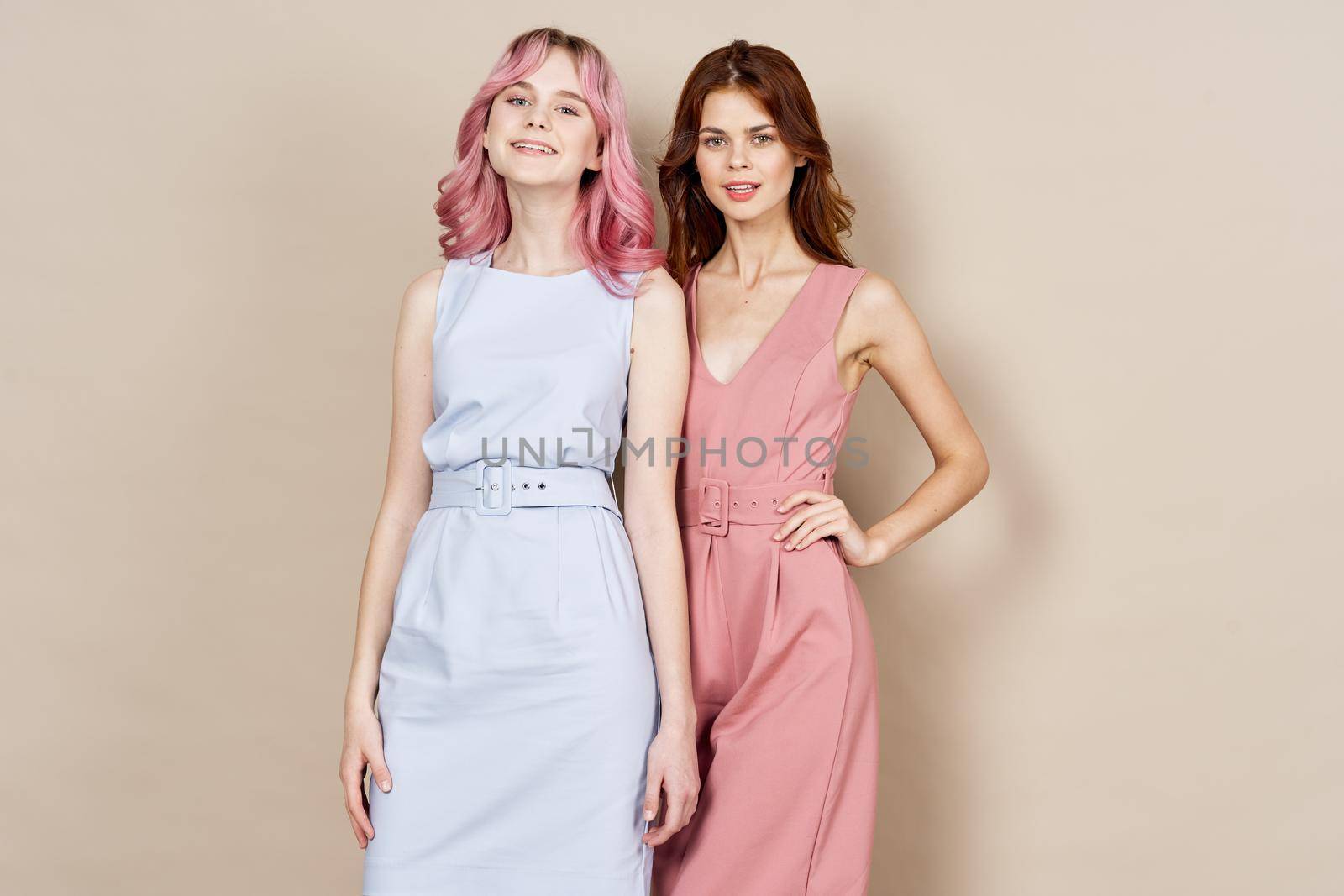 two girlfriends stand side by side fashion clothing glamor posing. High quality photo