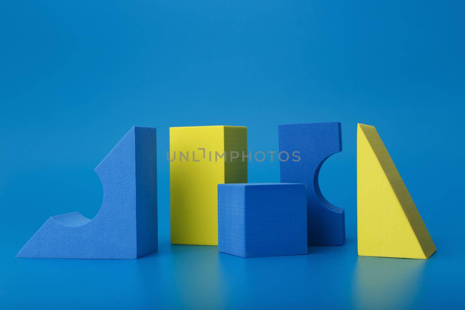 Abstract trendy futuristic background with blue and yellow geometric figures. Bright artsy background with different geometric shapes on blue background