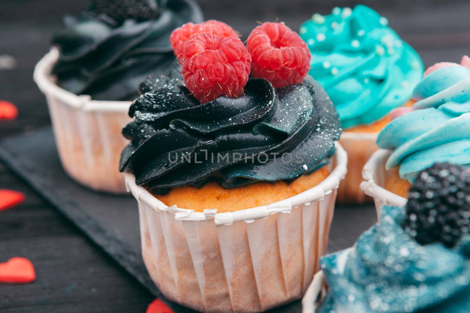 Set of different delicious cupcakes on dark