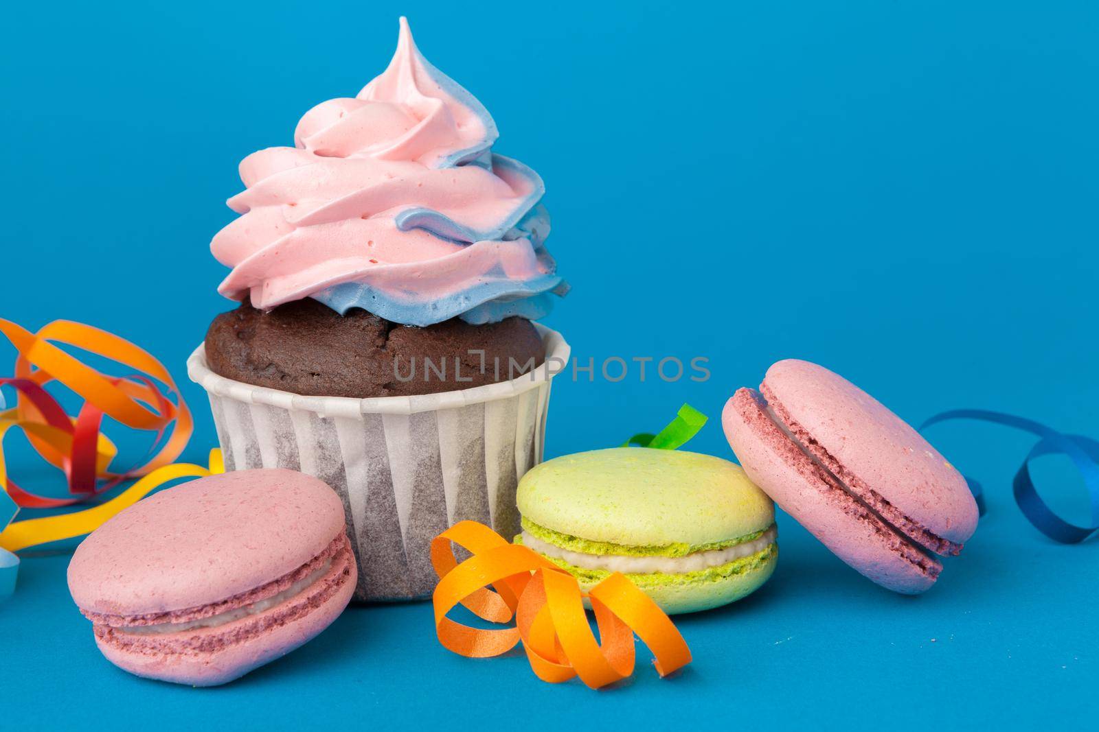 Birthday cupcakes on blue background close up