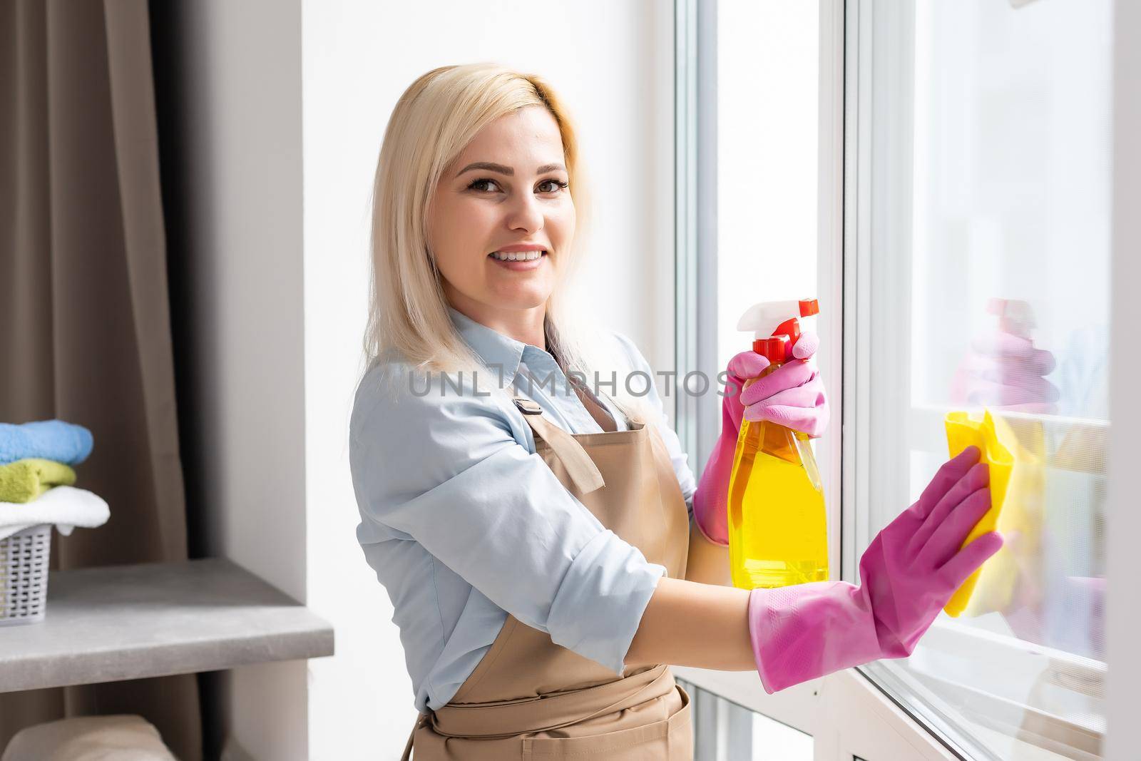 Young woman cleaning the window