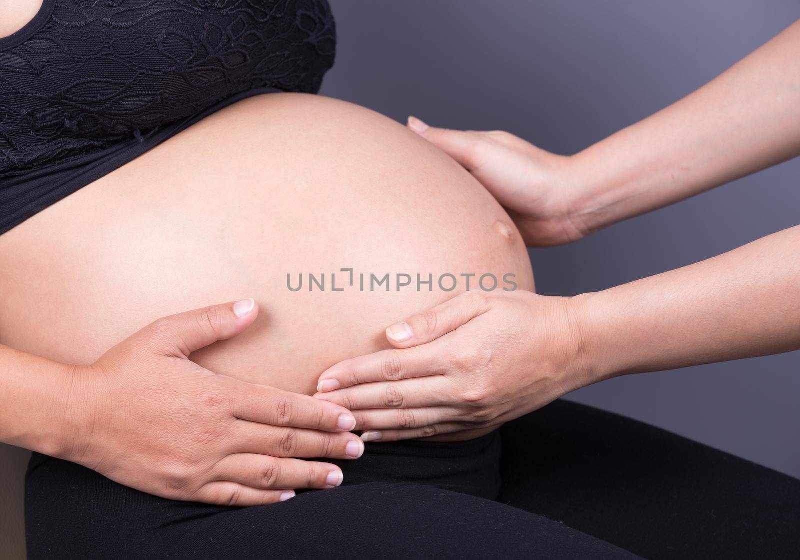 hand touching belly of pregnant woman  by geargodz