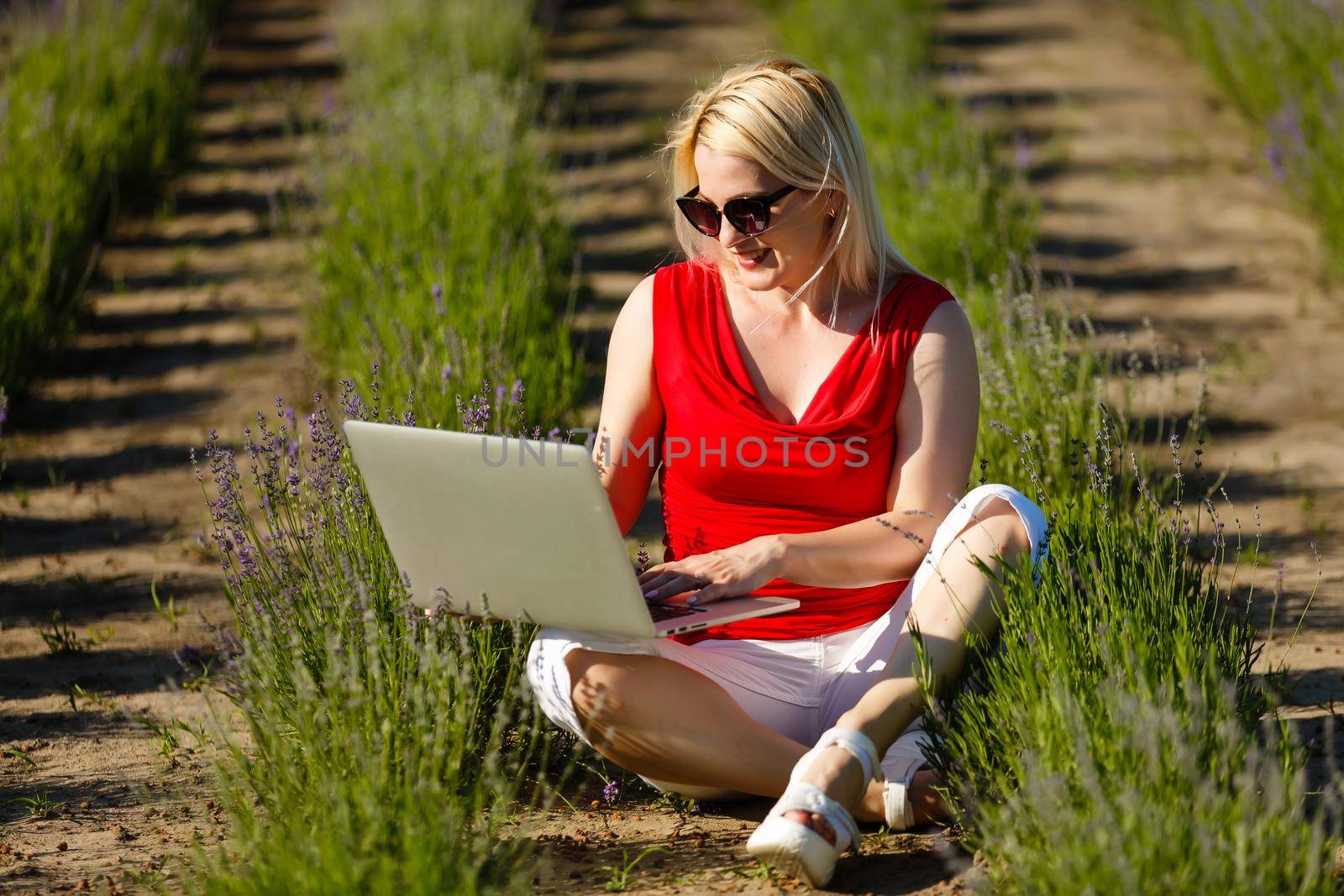 Portrait of a woman buying online or booking hotel with a laptop and credit card on the beach in vacations. E commerce concept