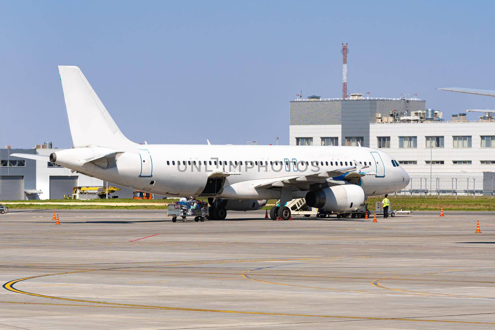 Airplane is parked near gate of airport terminal on sunny day