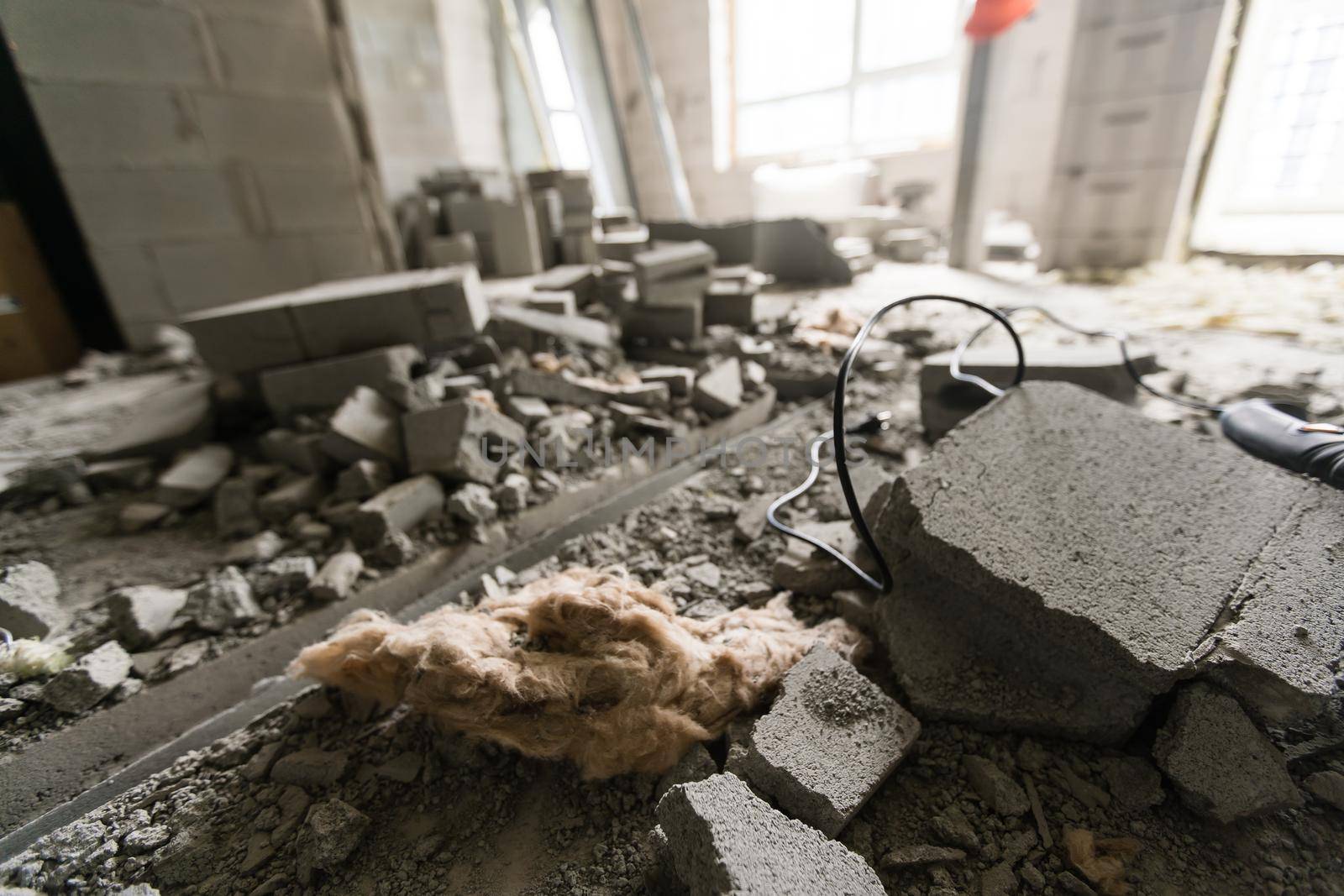 Break the wall for renovation and build the door for entrance of building. Wheelbarrow with broken bricks in site construction.