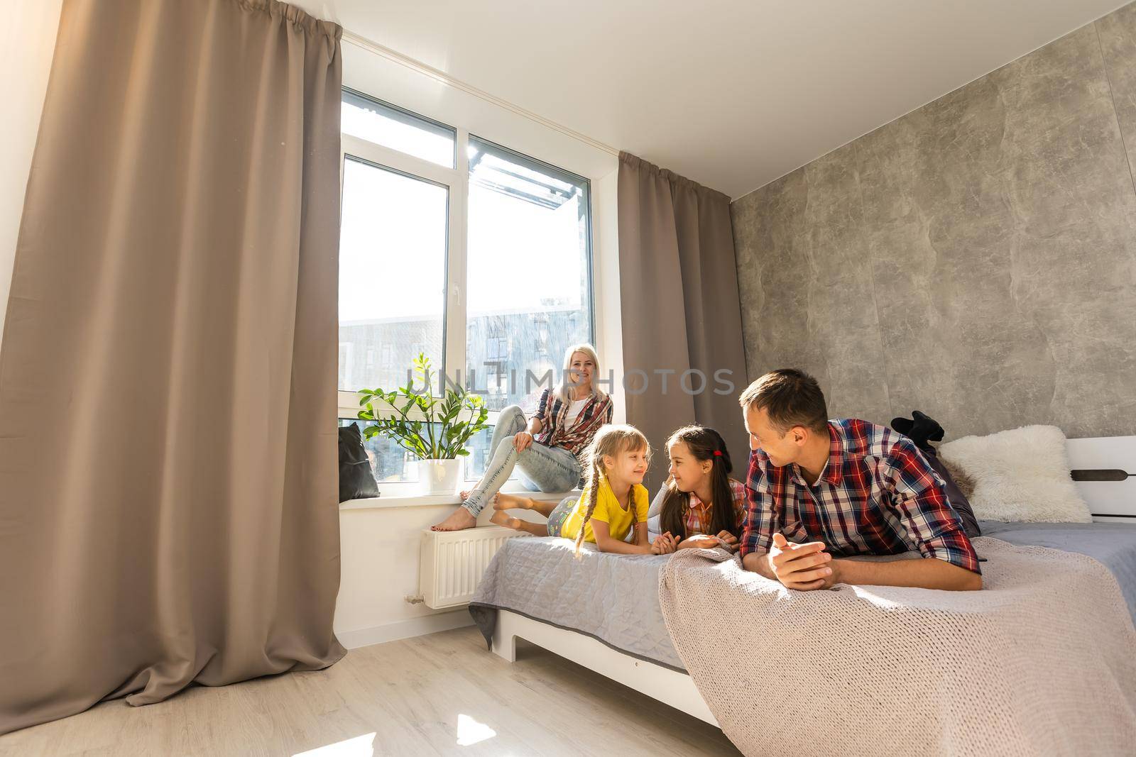 A happy family on white bed in the bedroom