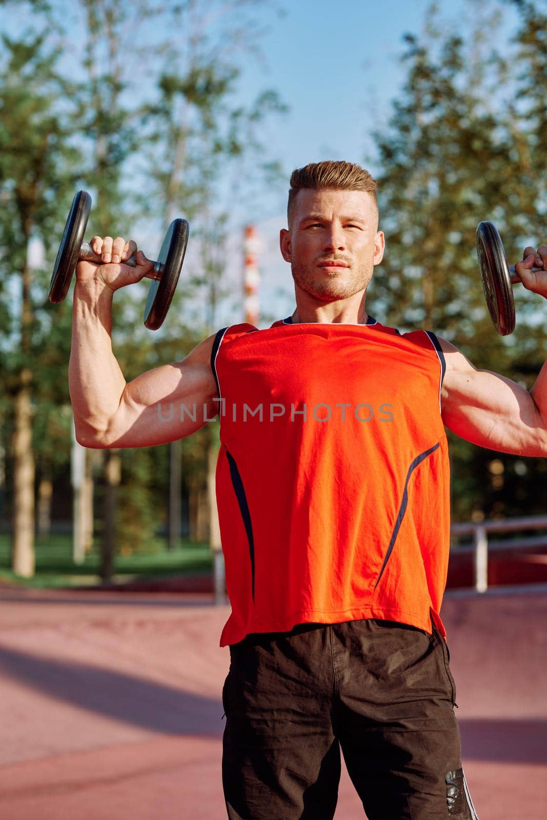 Muscled Man With Dumbbells Outdoor Workout. High quality photo