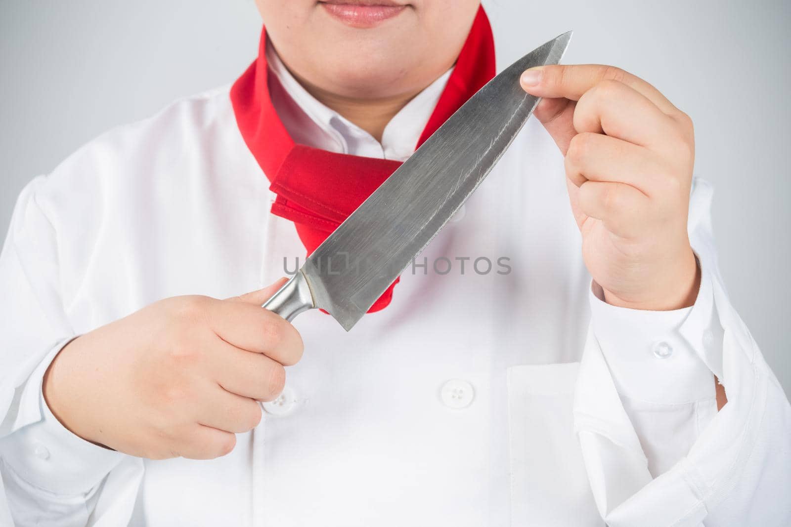 Closeup portrait of a male chef cook sharpening knife isolated on a white background
