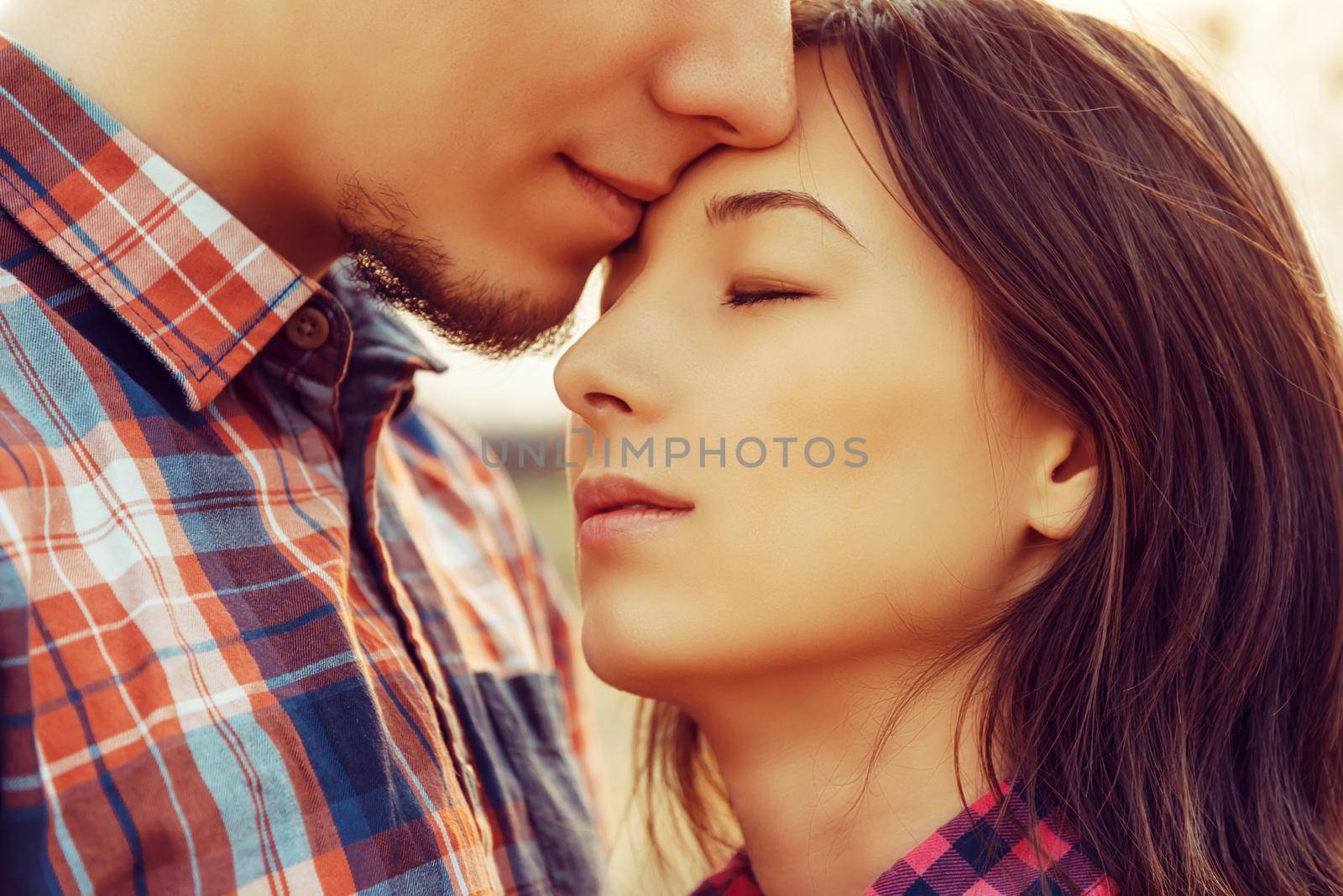 Man kisses woman with closed eyes, tranquil scene