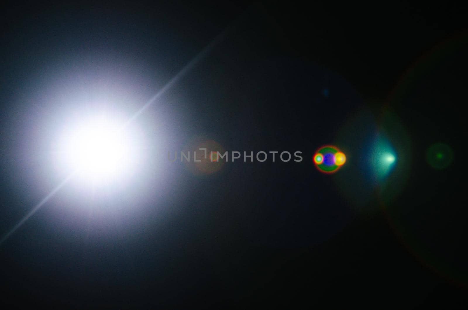Abstract Natural Sun flare or Far star on the black background - image